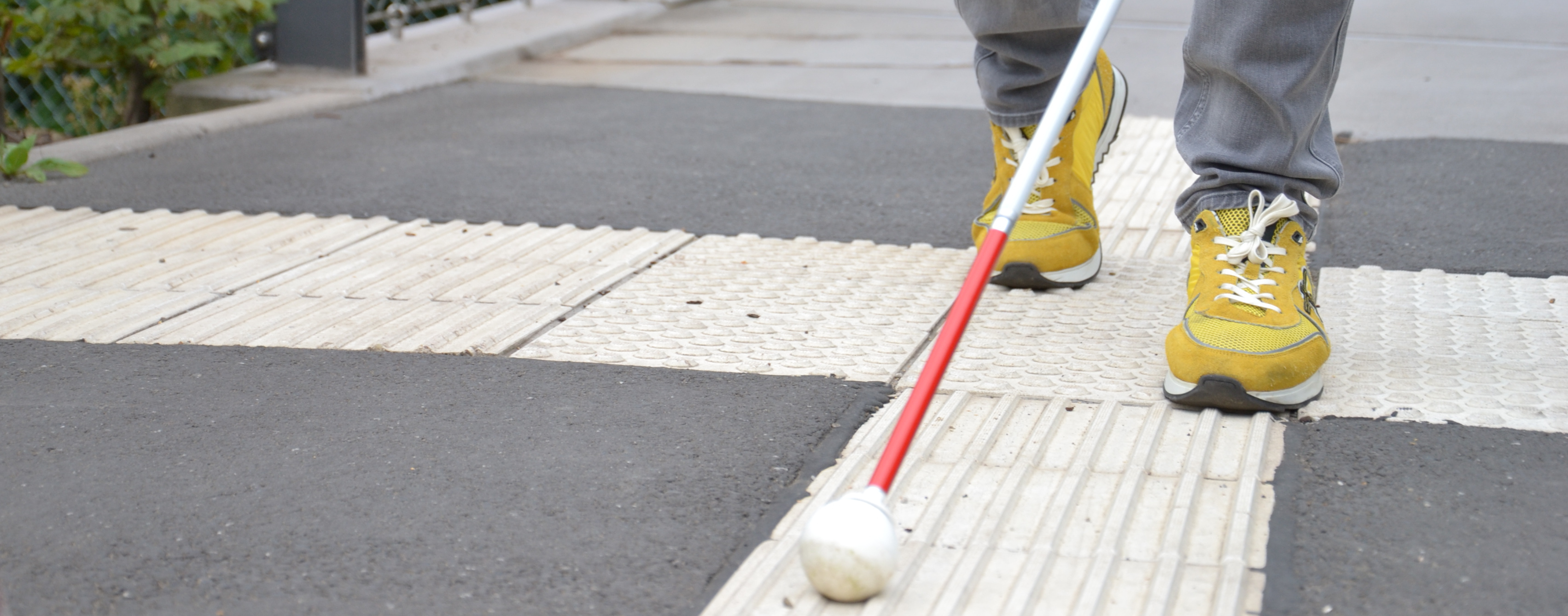 Bild von Füßen und Blindenstock.